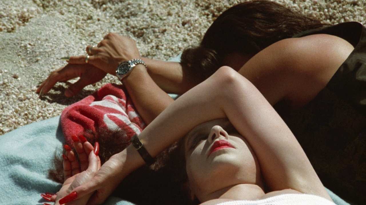 two women laying on a beach towel